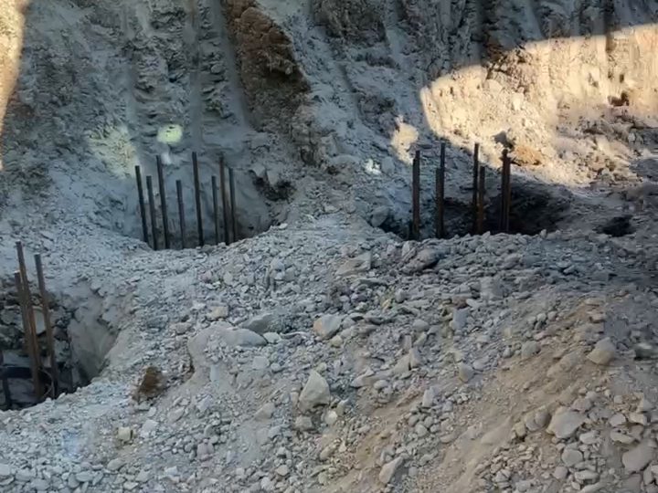 Ряд скважин с каркасами вдоль подрезанного склона